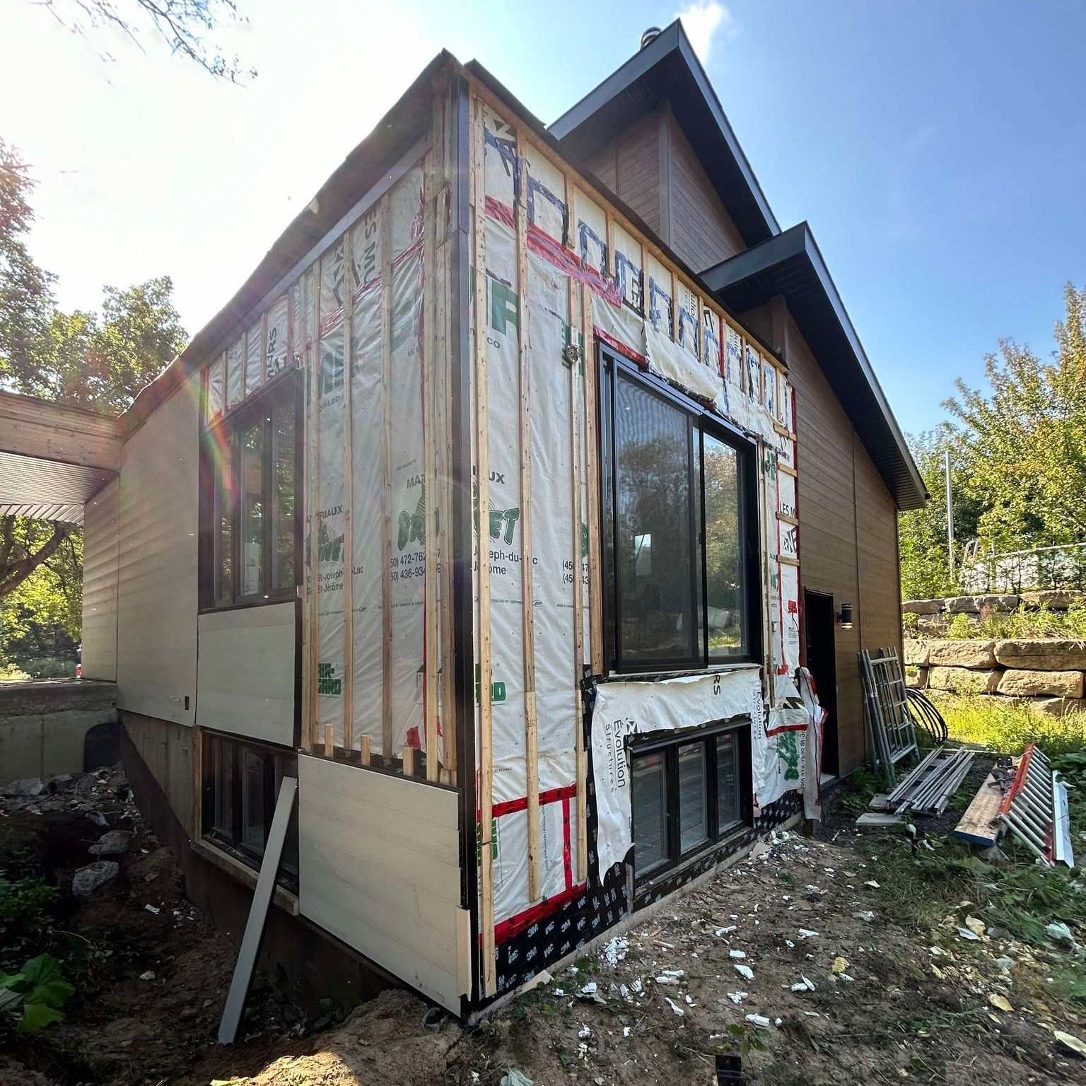 Une maison avec beaucoup de fenêtres est en cours de rénovation.