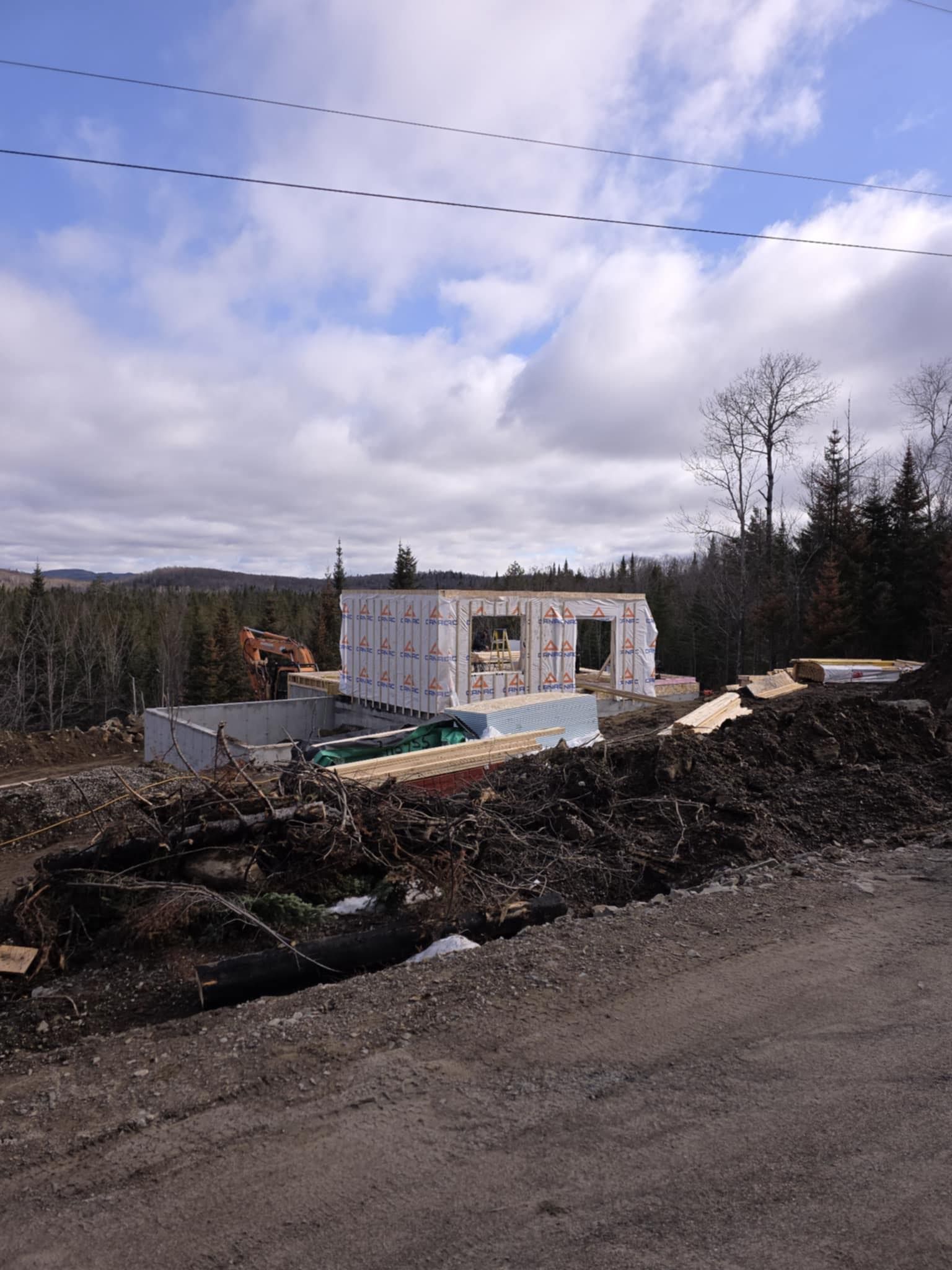 Une maison est en construction au milieu d'un champ de terre.
