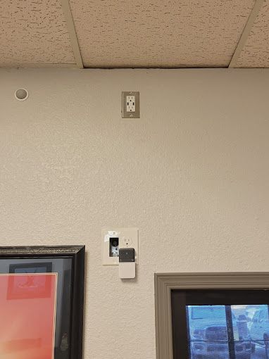 A white wall with a picture on it and a ceiling.