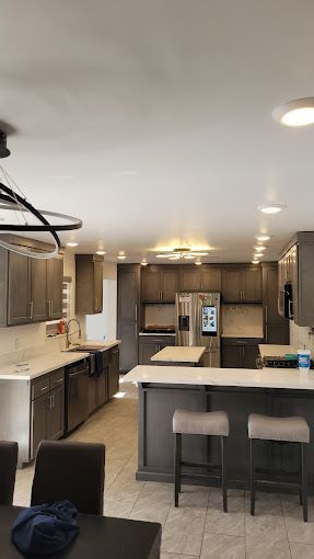 A kitchen with stainless steel appliances , a refrigerator , a sink , and a table.