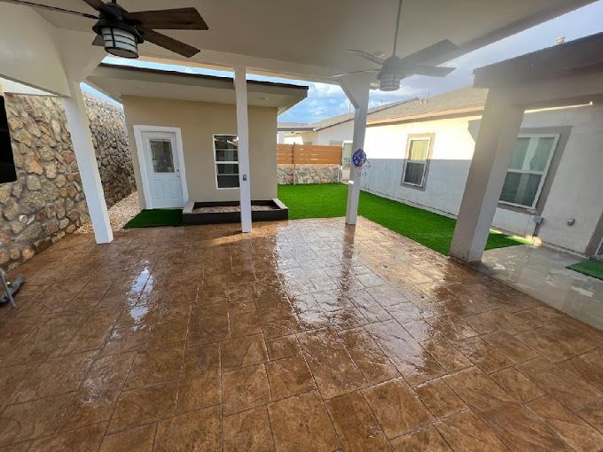 There is a ceiling fan in the backyard of a house.