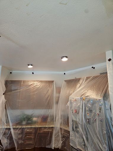 A kitchen is covered in plastic and ready to be painted.