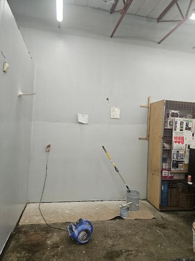 A room with a vacuum cleaner and a mop on the floor.