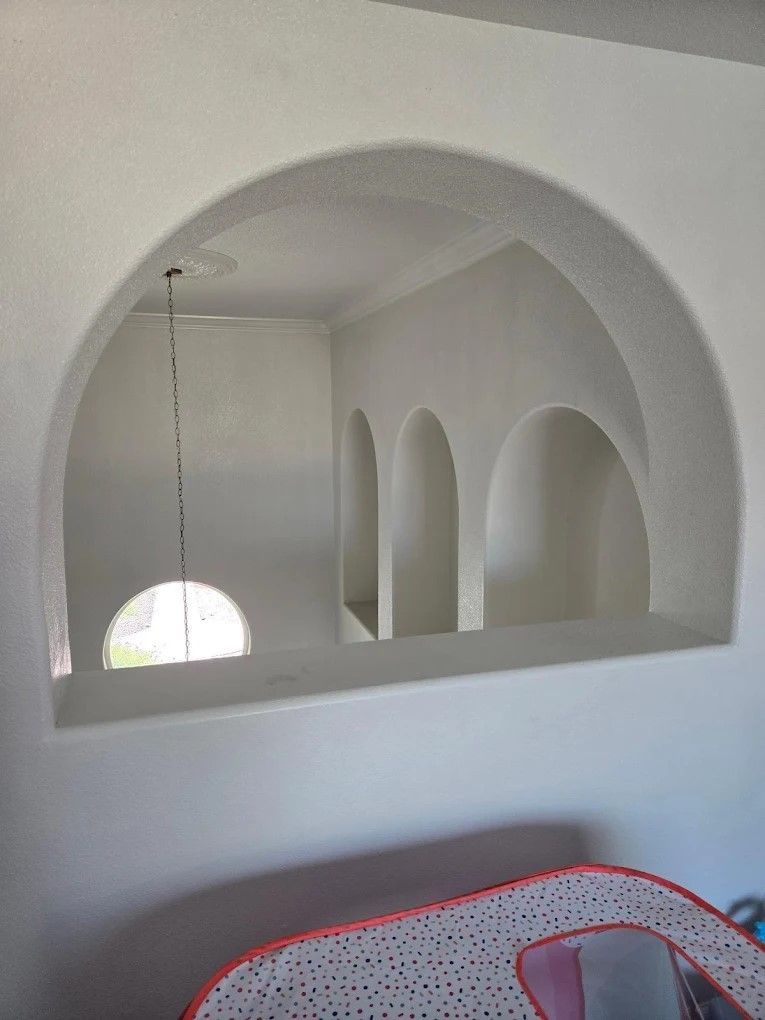 A man is plastering a wall with a trowel.