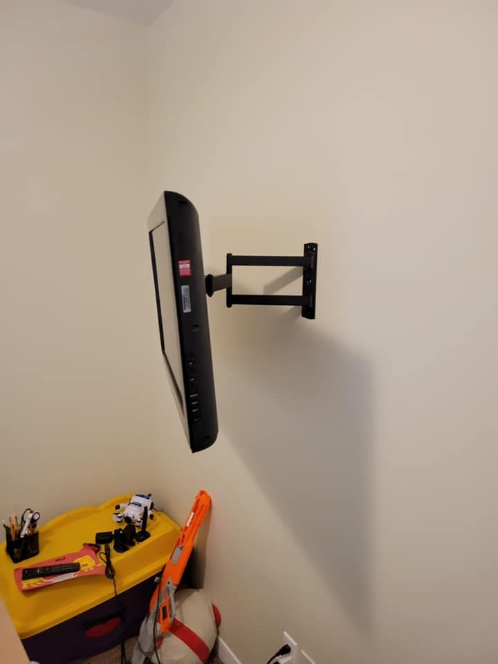 A tv mounted on a wall next to a yellow box