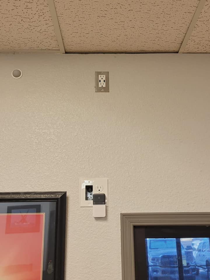 A white wall with a picture on it and a ceiling.