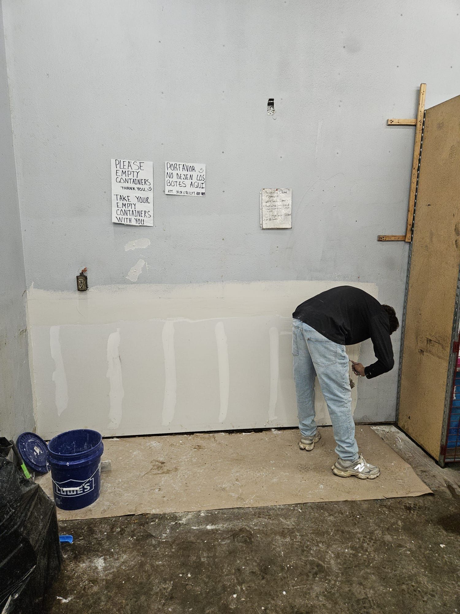 A man is painting a wall in a room.
