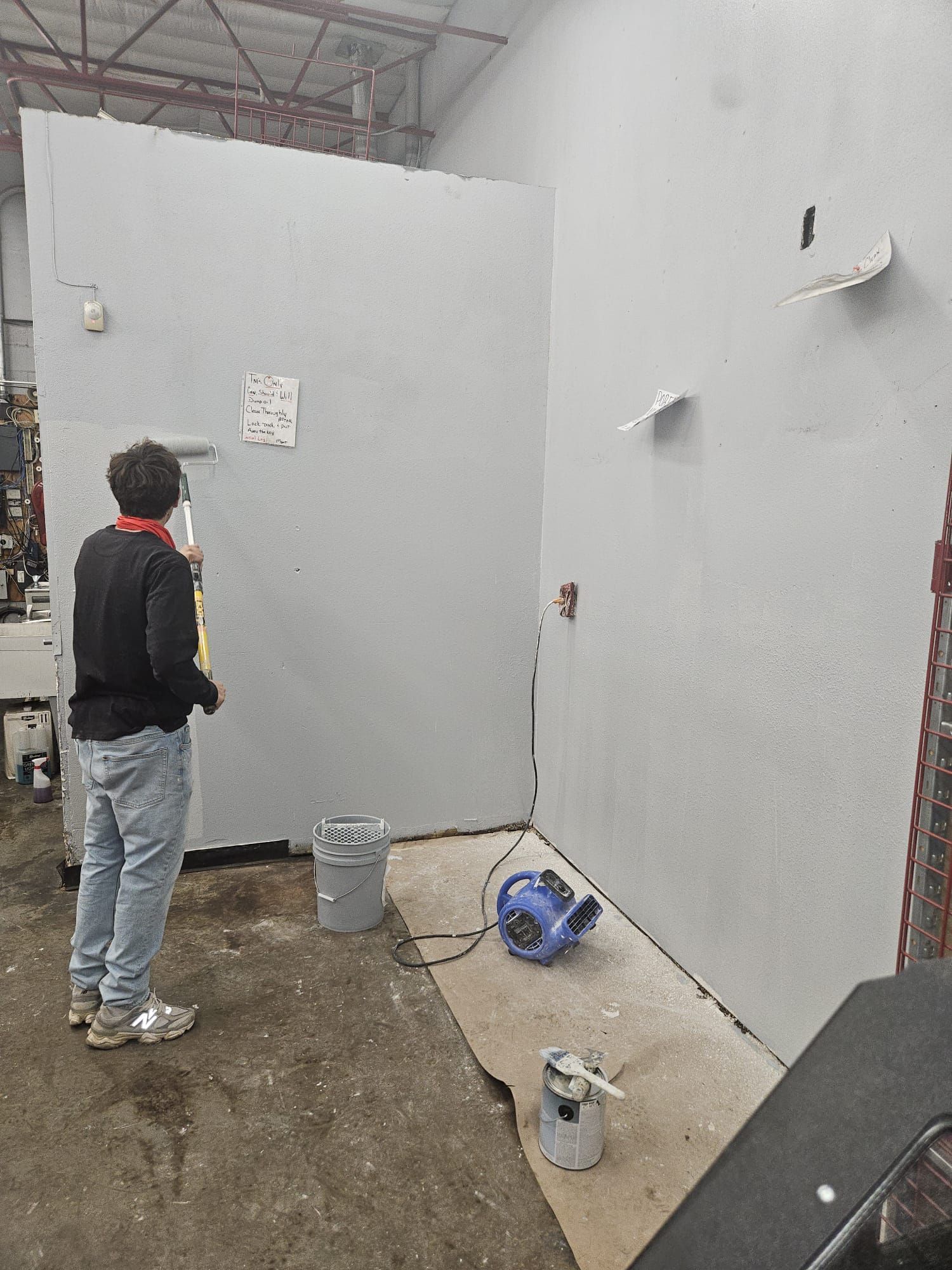 A man is painting a wall in a room.
