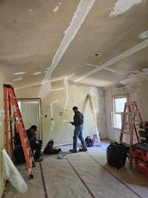 A man is standing in a room with a ladder.