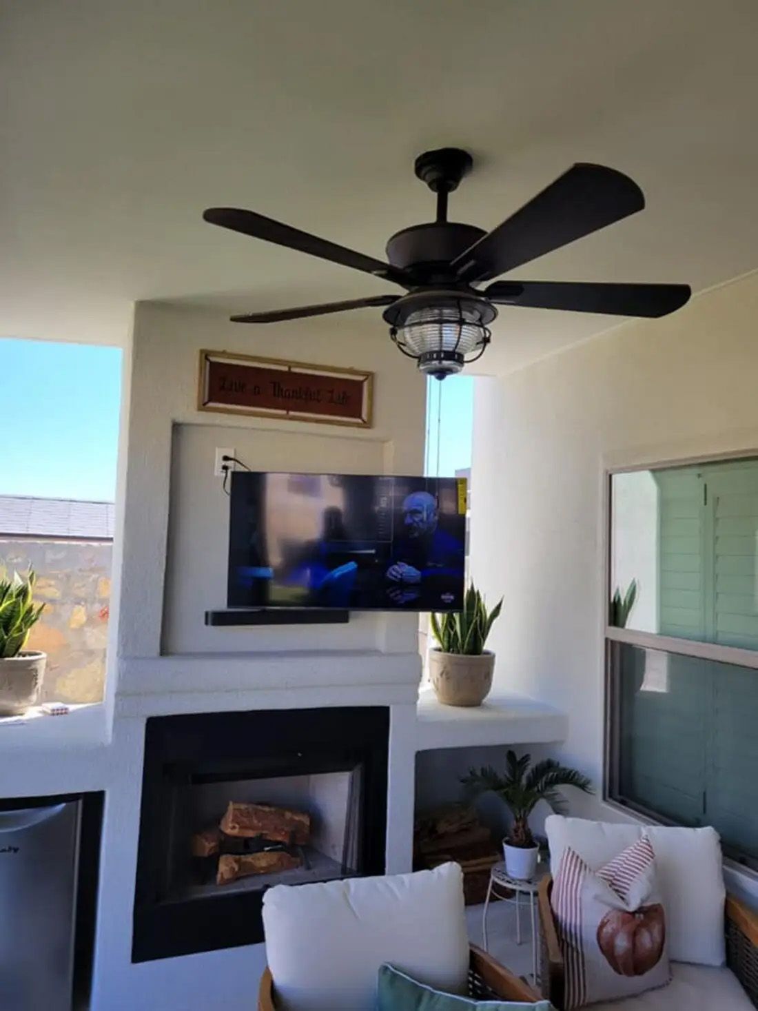 A living room with a fireplace and a ceiling fan.