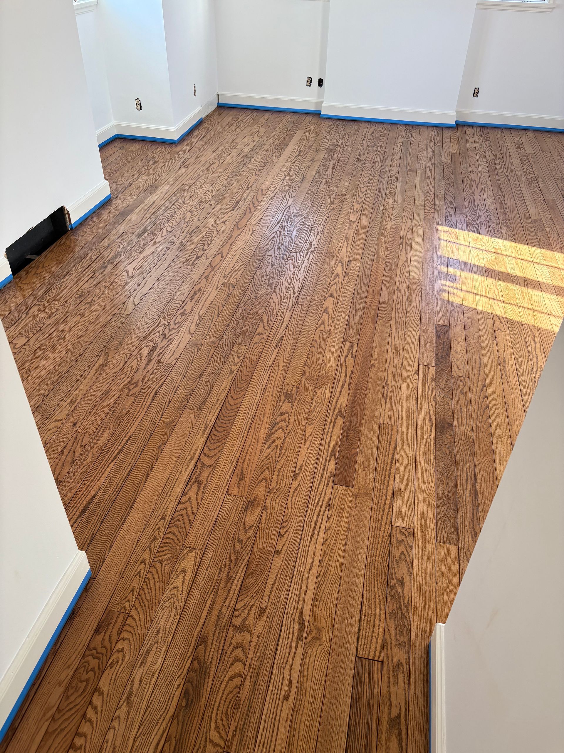 Image Showing a side-by-side comparison of a hardwood floor install. 