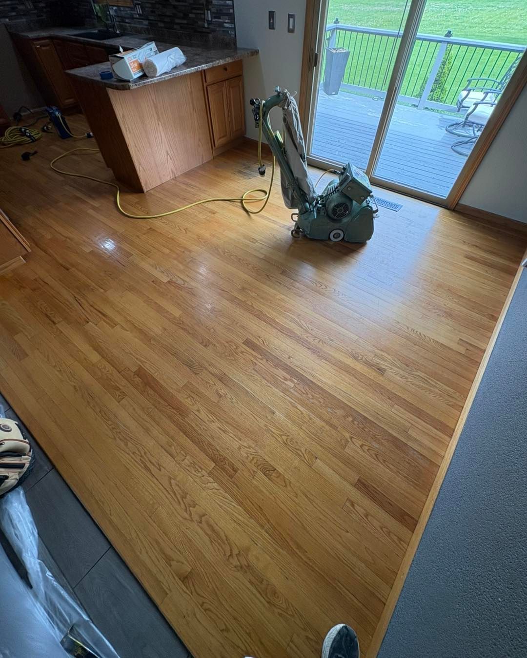 Image showing InfinityFlooring buffing a wood floor here in Sioux City. You can see the wood floor in the process of getting refinished in the living room. 