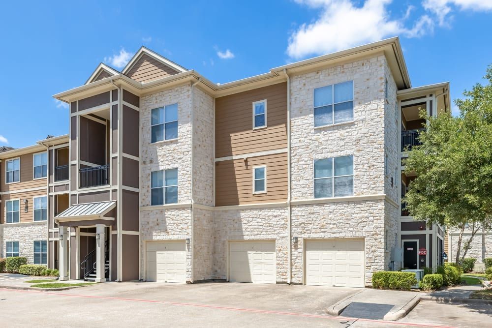 Apartment buildings with a lot of windows and garages at Marquis at The Woodlands in Spring, TX.