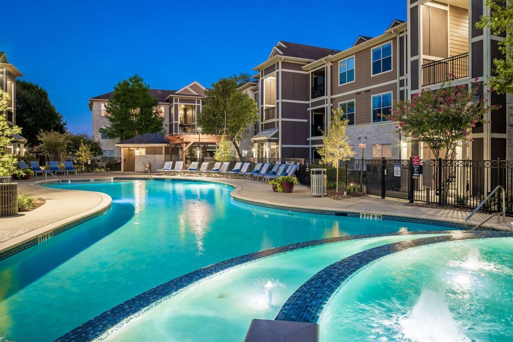 Apartment swimming pool at night at Marquis at The Woodlands in Spring, TX.