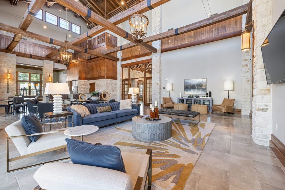 Spacious high-ceiling clubhouse house filled with furniture and television at Marquis at The Woodlands in Spring, TX.