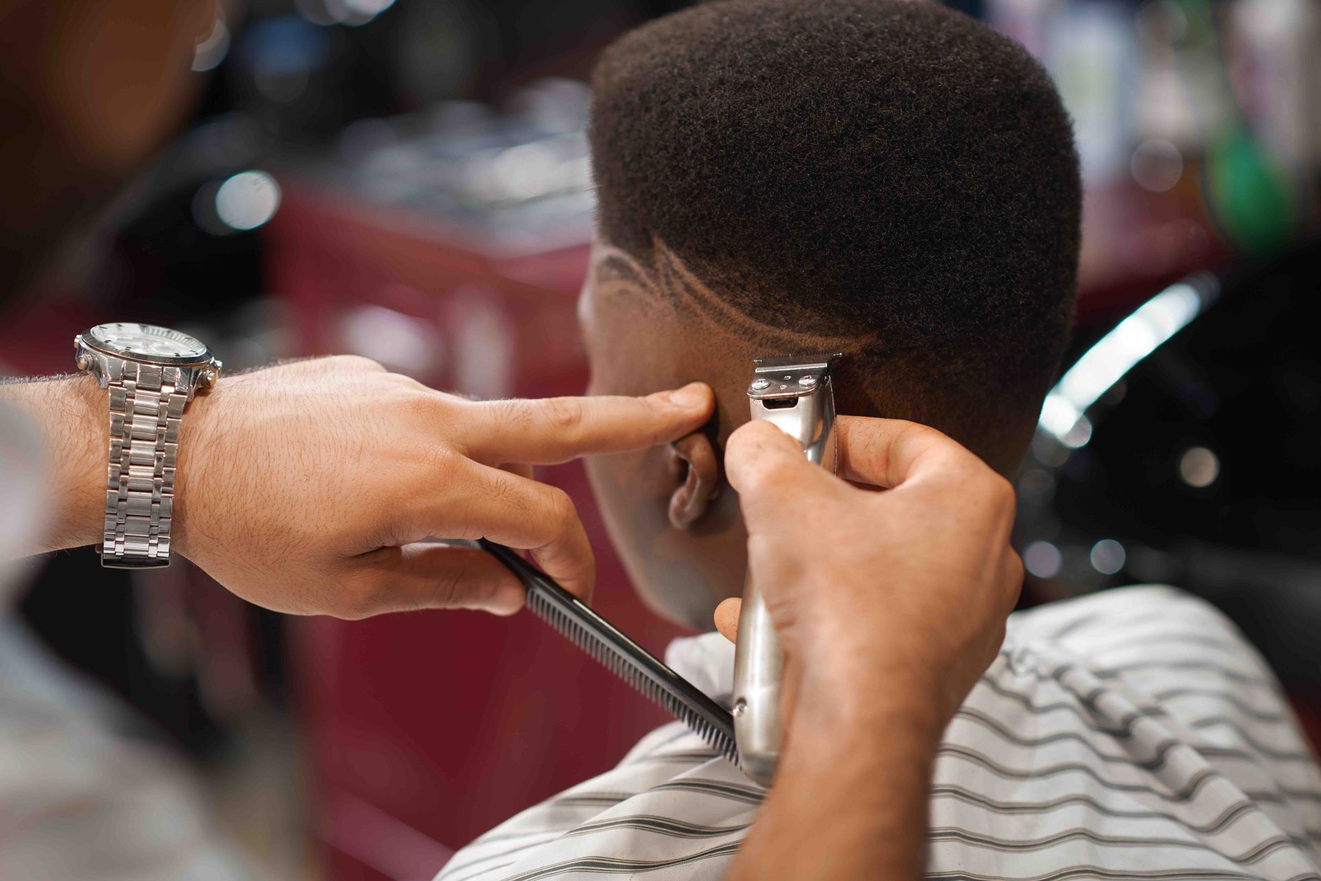 A man is getting his hair cut by a barber in a barber shop.