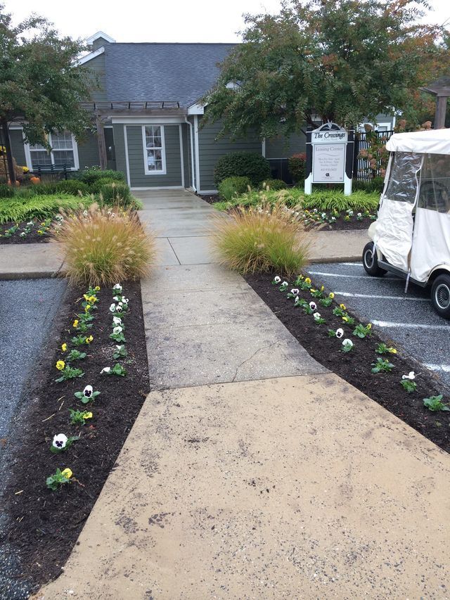 Pathway to a building with landscaping and golf cart parked nearby.