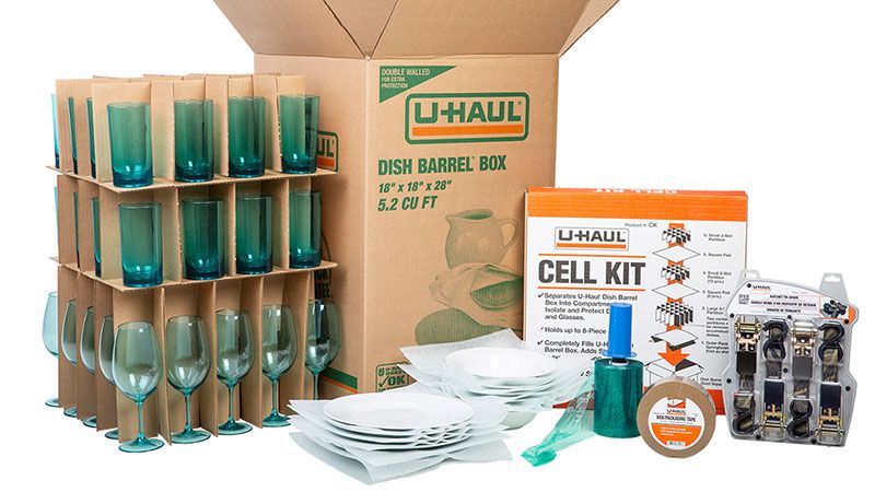 a u-haul box filled with wine glasses and a cell kit