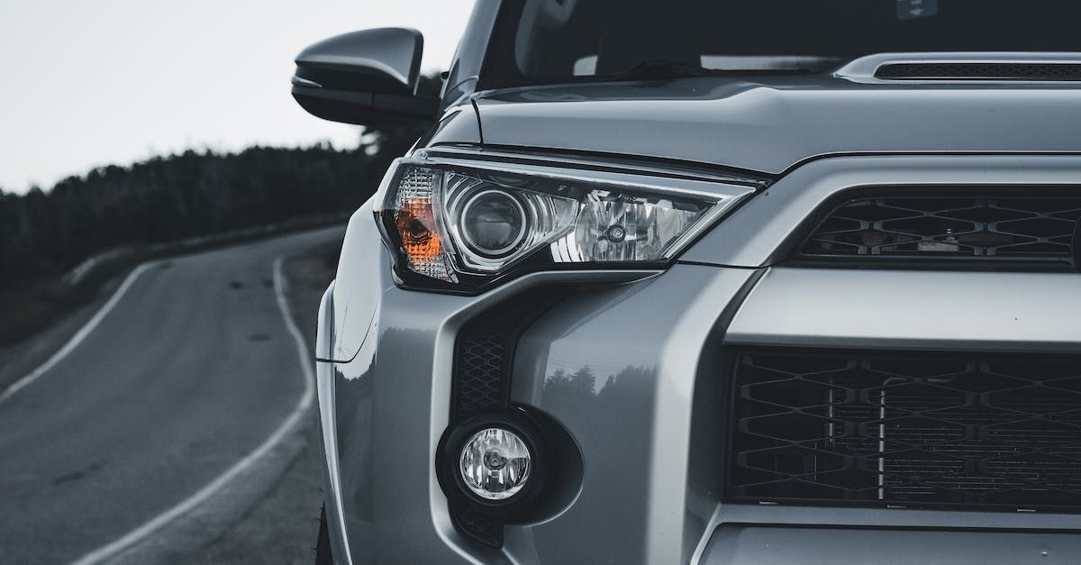 Silver Toyota 4Runner on a curved road, close-up of the front.