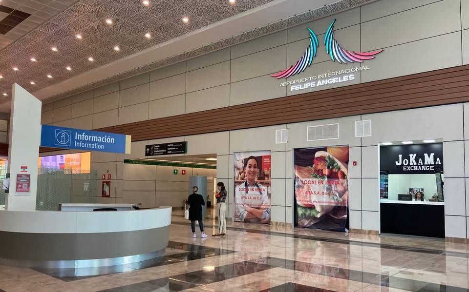 Interior del Aeropuerto Internacional Felipe Ángeles con mostrador de información y tiendas. Hay gente.