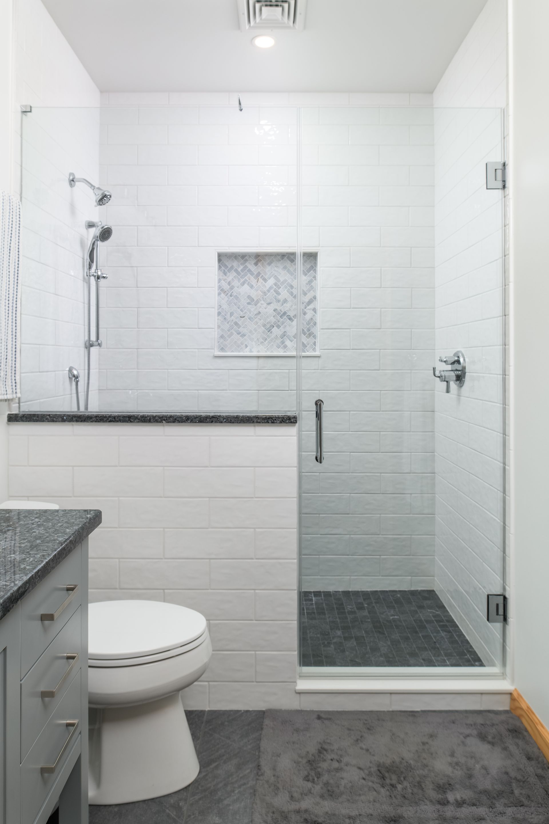 A bathroom with a toilet , sink , and walk in shower.