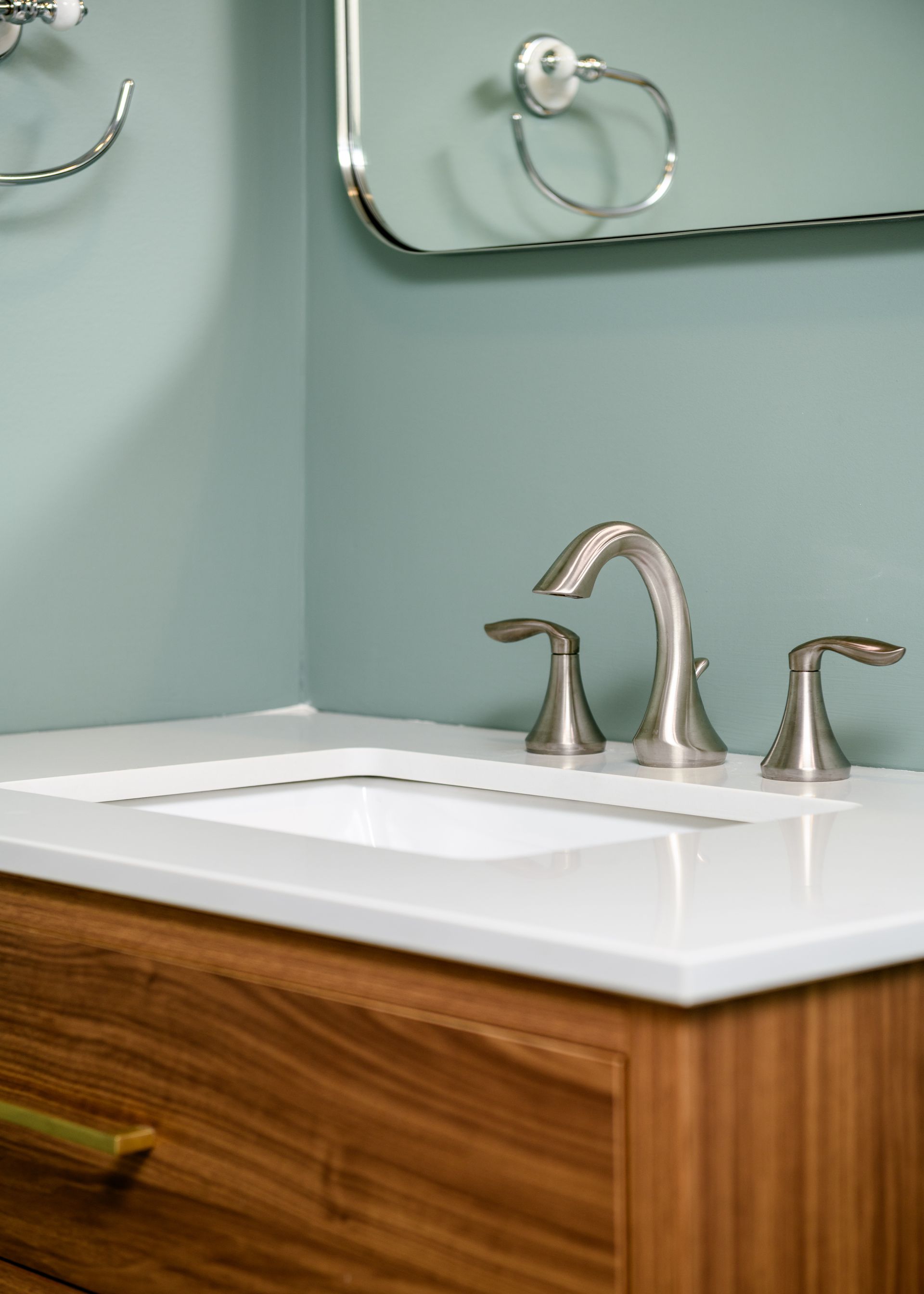 A bathroom sink with a wooden cabinet and a mirror.