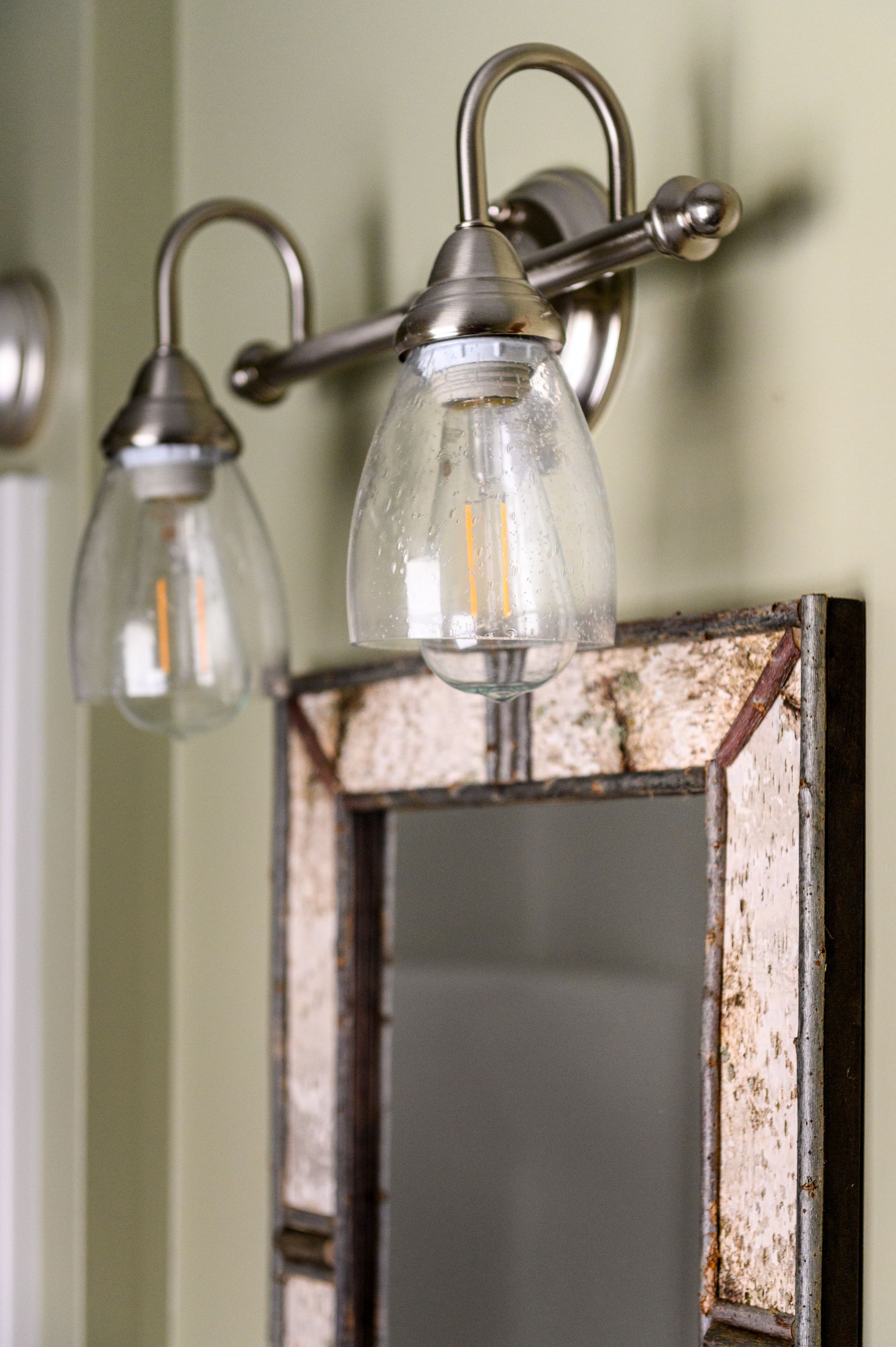 A bathroom mirror with a light above it