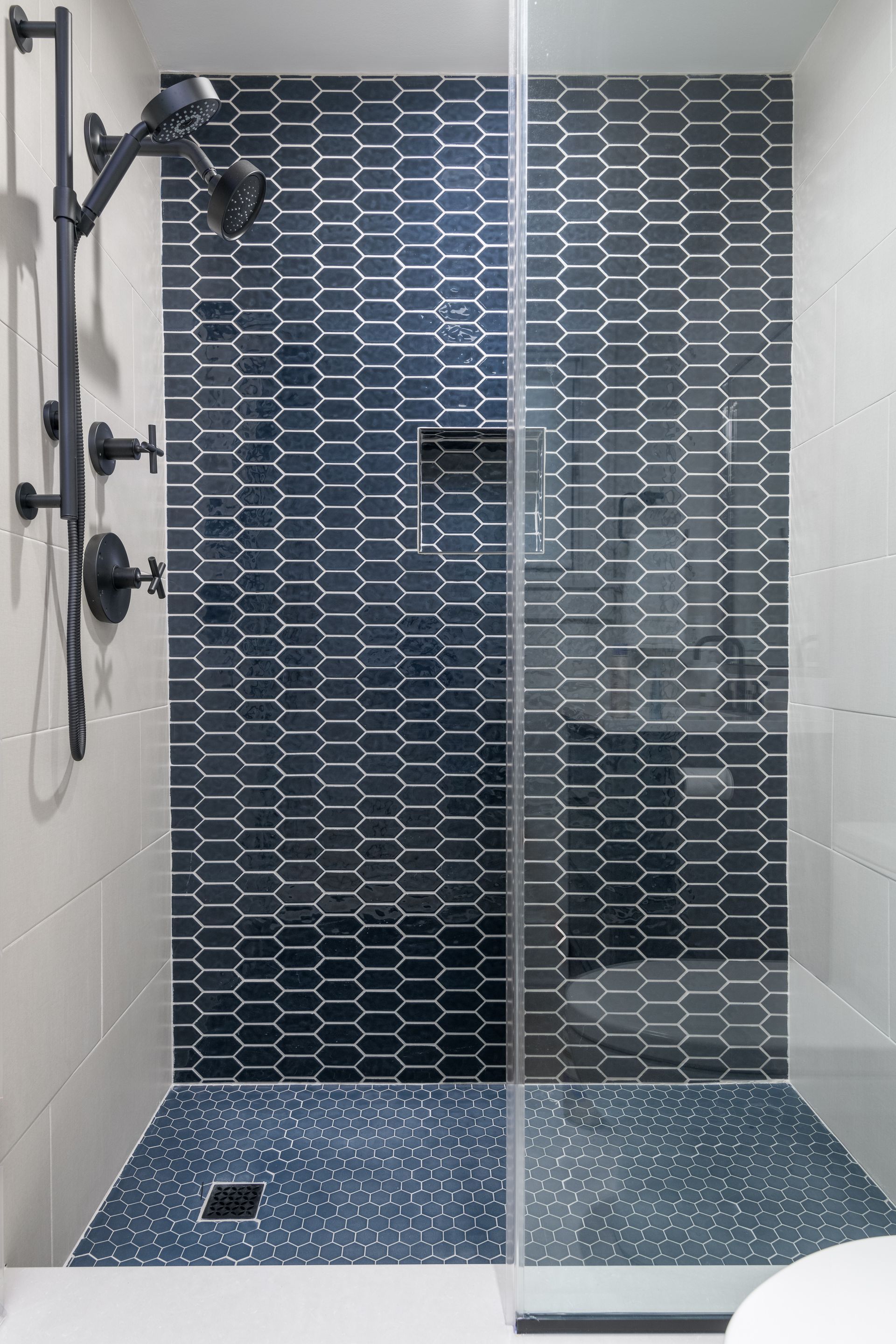 A bathroom with a walk in shower and a toilet.