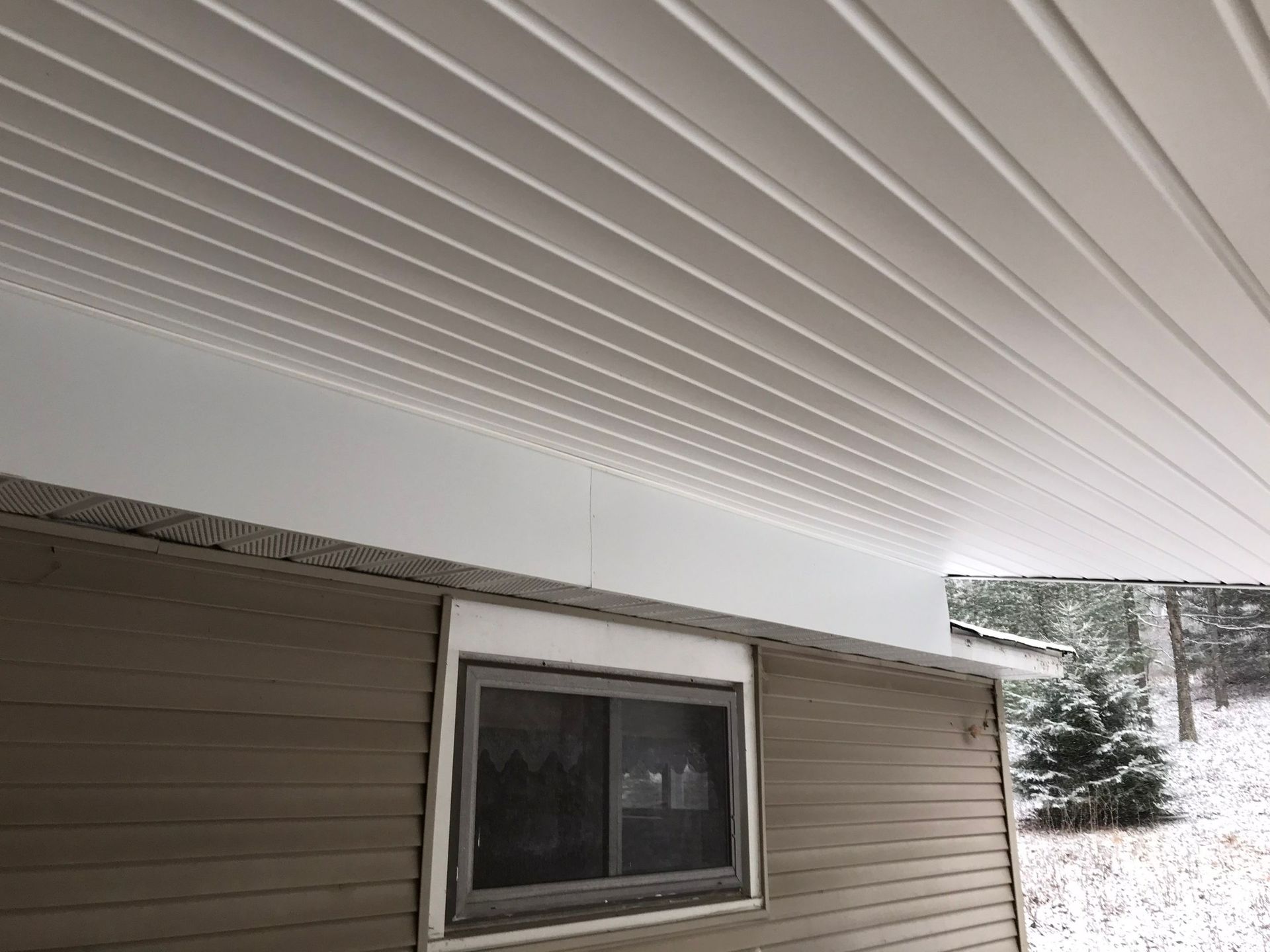 The ceiling of a house with a window and a sliding glass door.