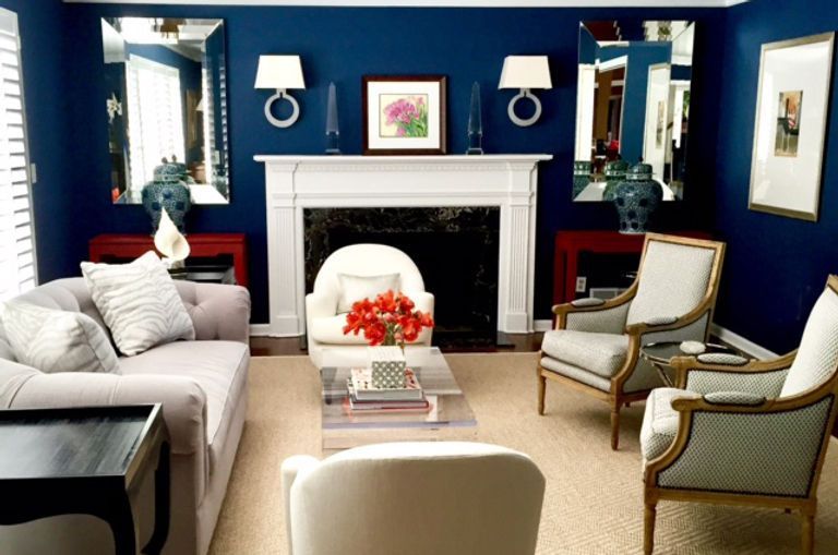 A living room with blue walls and white furniture