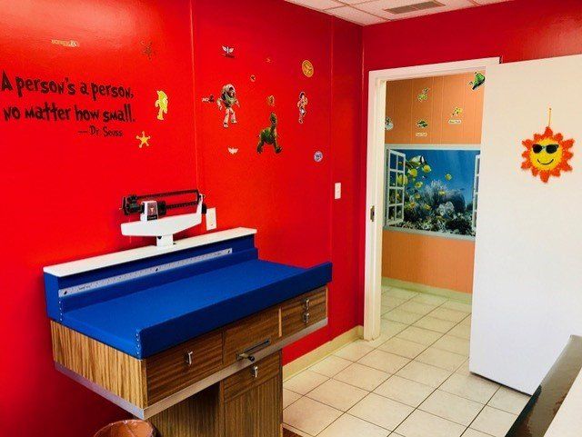 Examination Room With Red Painted Wall — Toms River, NJ — Sunny Pediatrics, Inc.