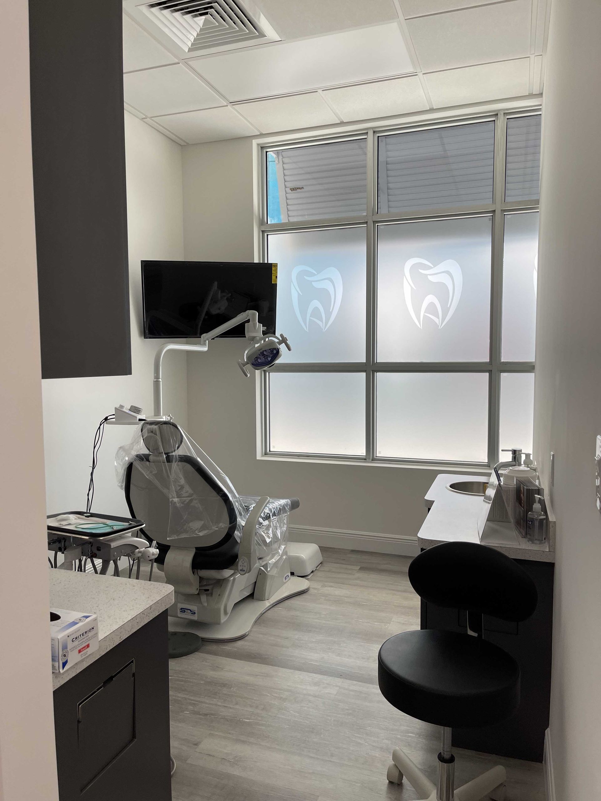 A dental office with a dental chair and a monitor