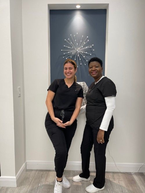 Two women in scrubs are standing next to each other in a room.