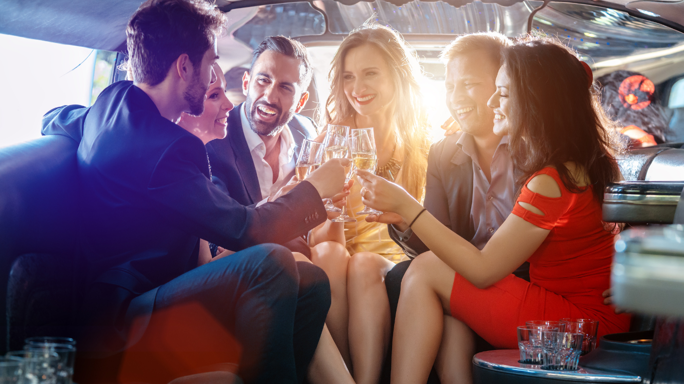 A group of people are sitting in a limousine toasting with wine glasses.