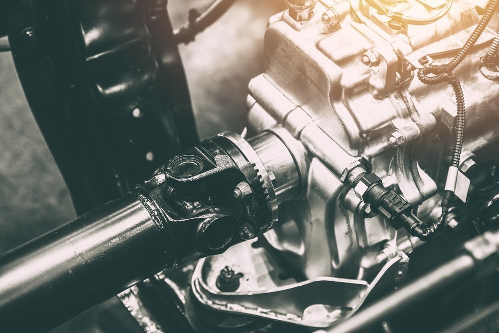 A close up of a car engine with a shaft.