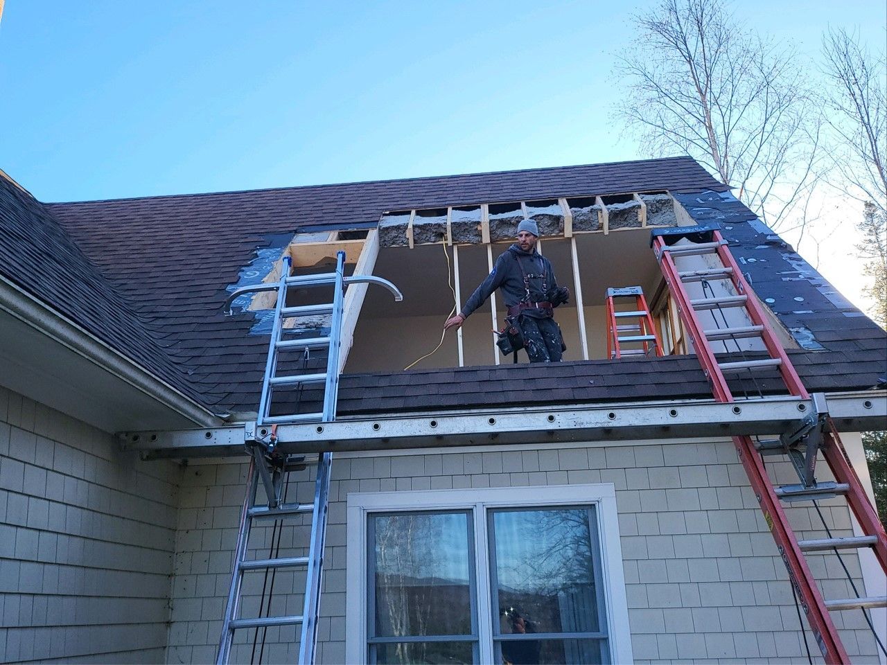 The roofing experts at Juggernaut Construction Company in Vermont repair a section of roof