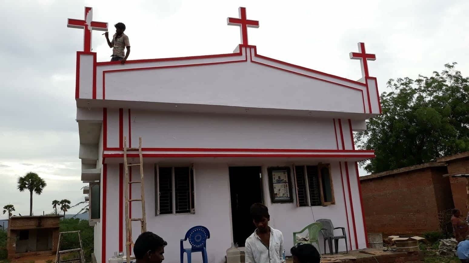 A man is standing on the roof of a building with crosses on it.