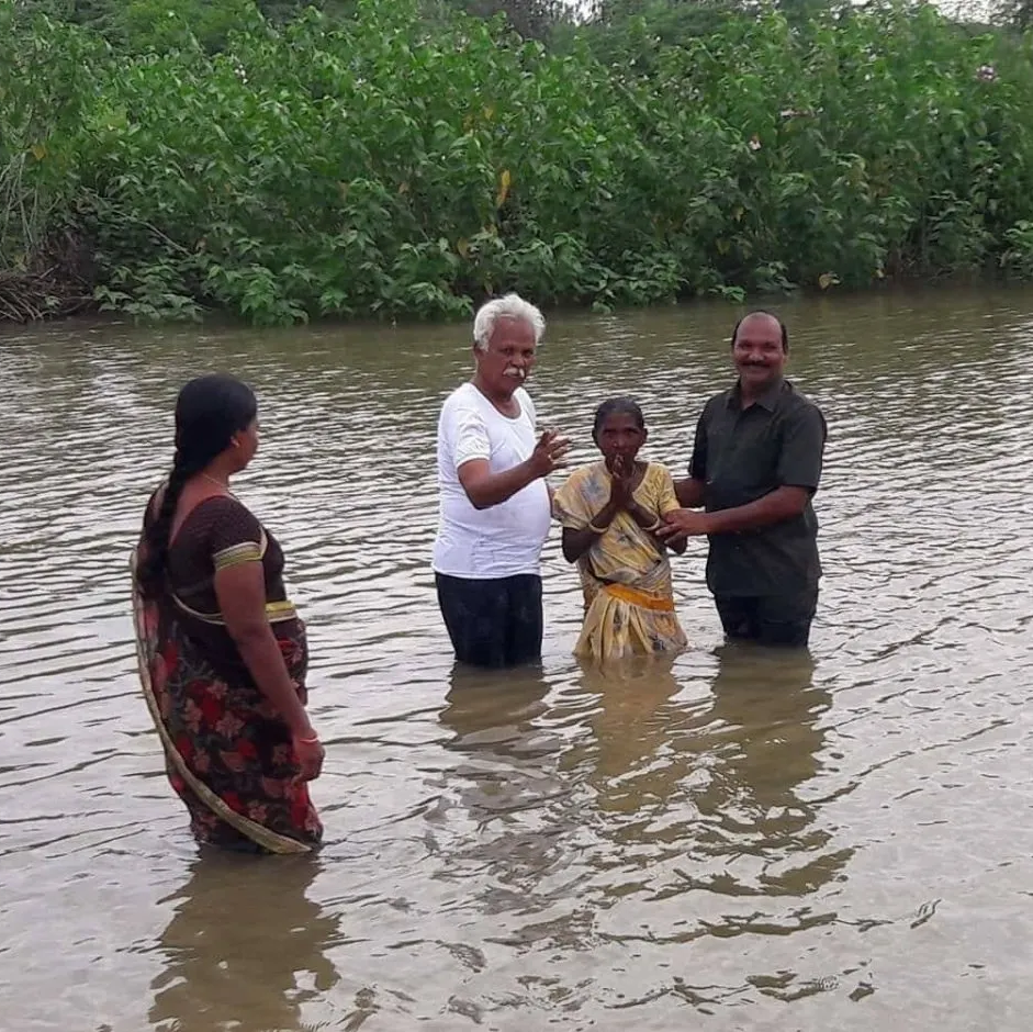 A group of people are standing in a body of water