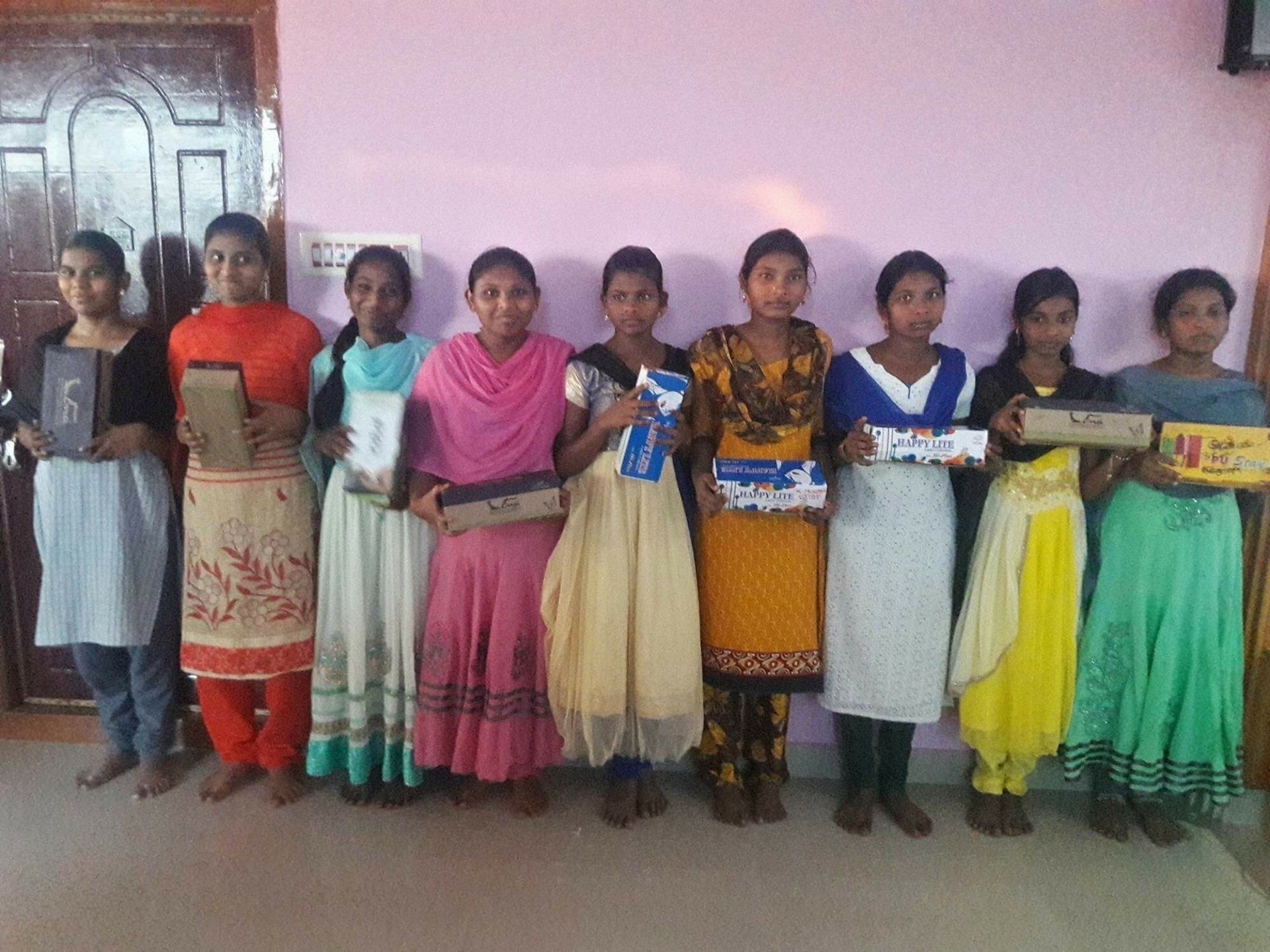 A group of girls are standing in a line holding books