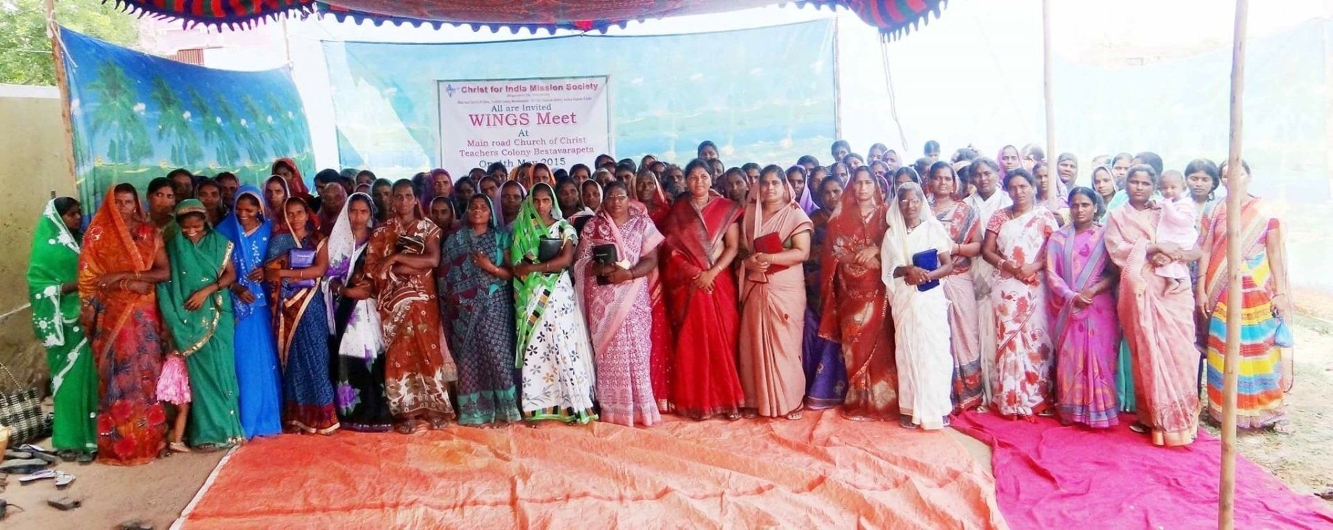 A large group of people are posing for a picture in front of a stage.