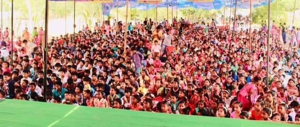 A large crowd of people are sitting in a stadium watching a game.