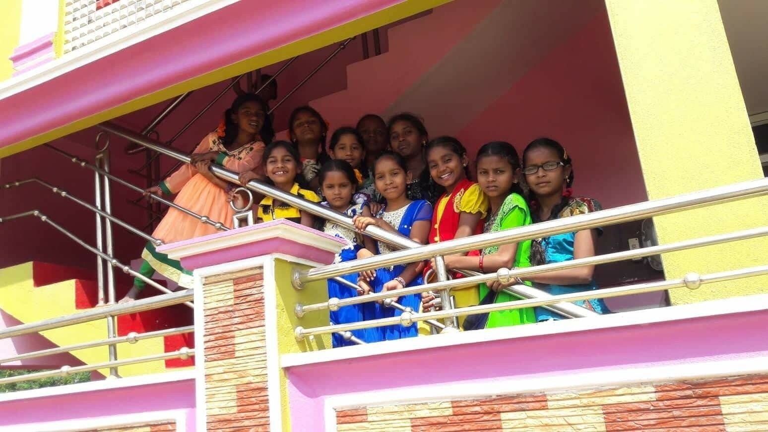 A group of women are posing for a picture on a balcony.