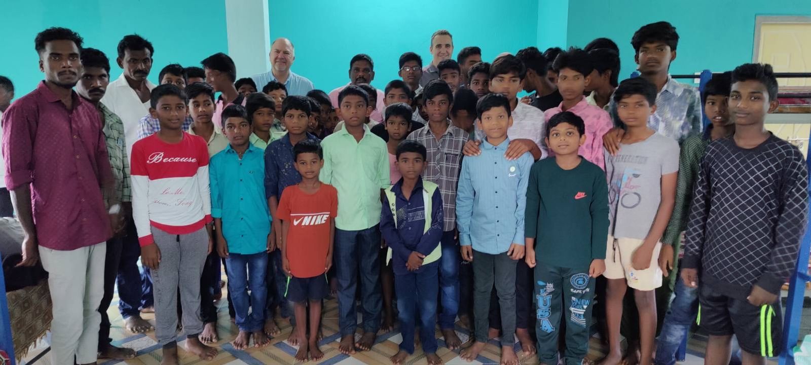 A group of young men are posing for a picture in a room.