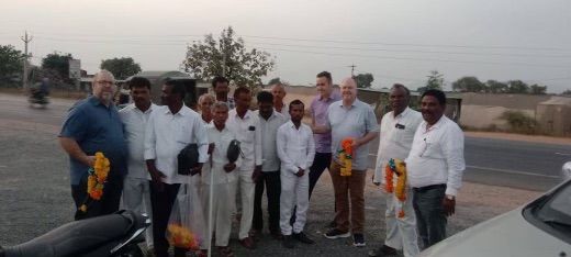 A group of people are standing next to each other on the side of the road.