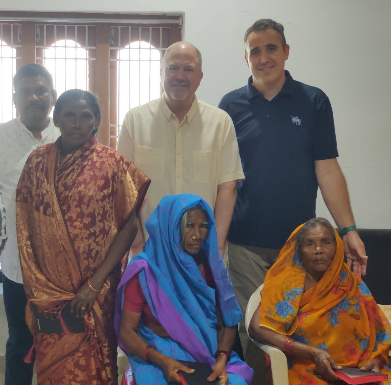 A group of people posing for a picture with one man wearing a blue shirt that says nike