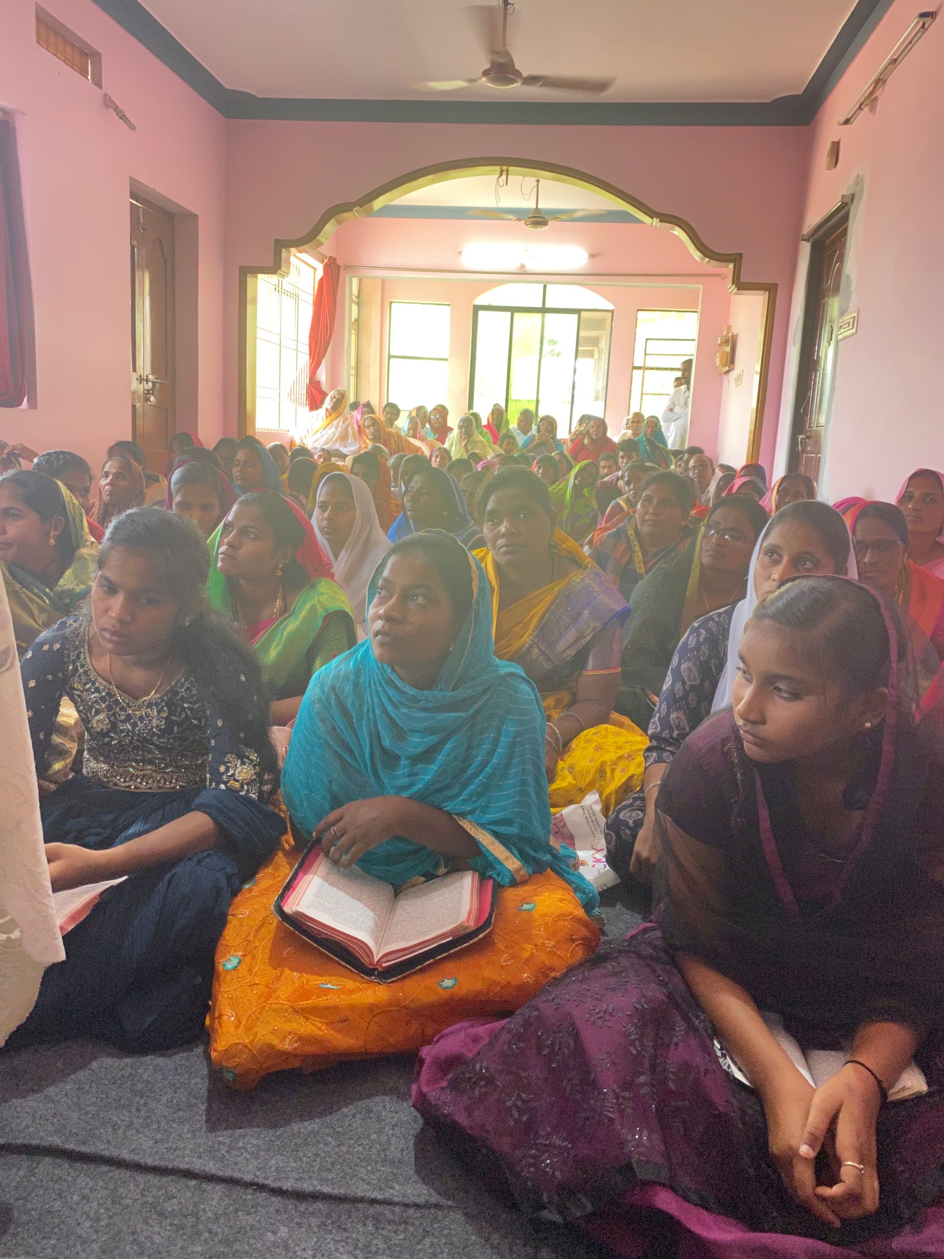A group of people are sitting on the floor in a room
