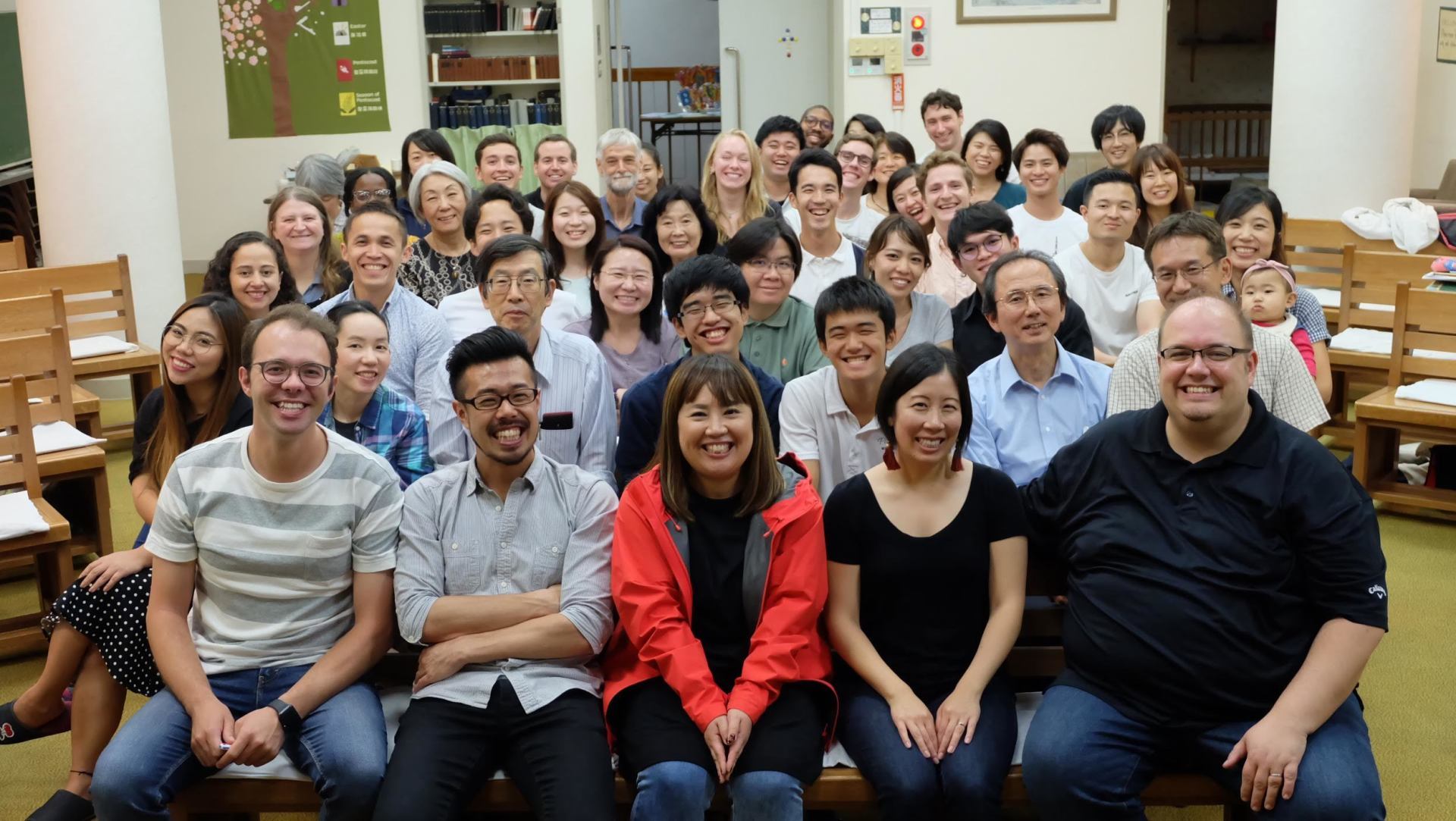 A large group of people are posing for a picture in a room.