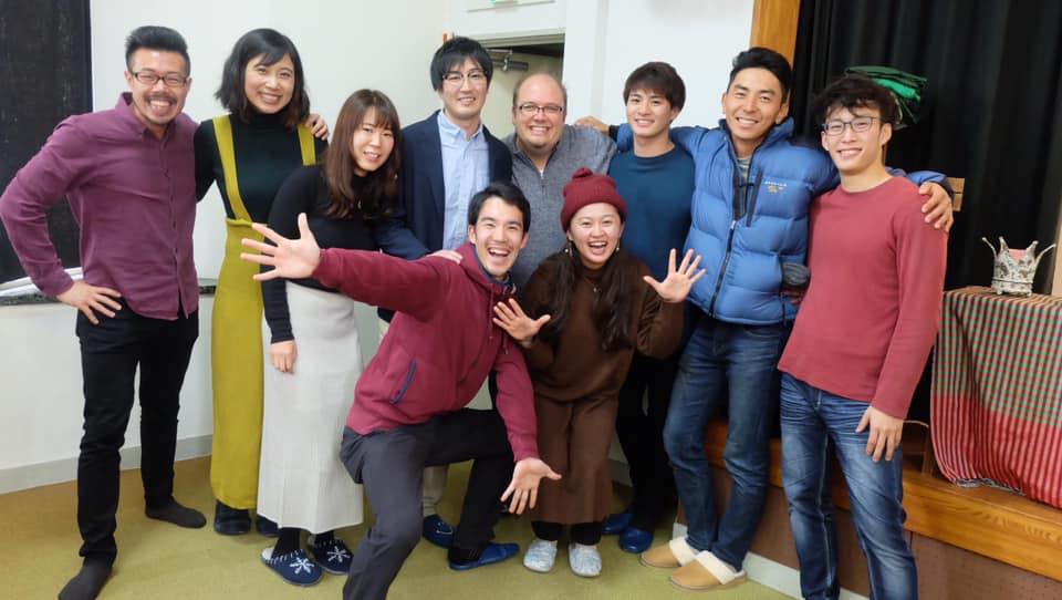 A group of people are posing for a picture together in a room.