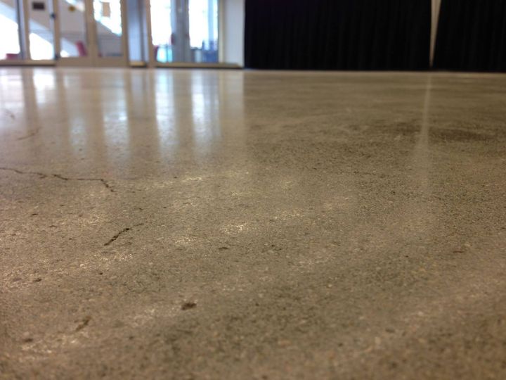 a close up of a concrete floor with a door in the background .