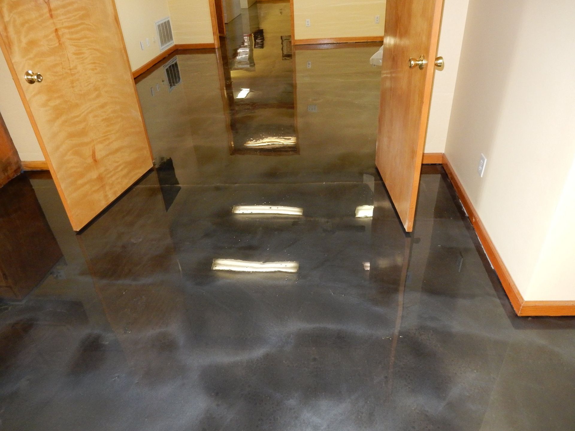 a hallway with a black floor and wooden doors